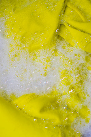 Close up of detergent and yellow cloth in washing machine for cleaningの写真素材