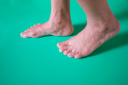 Feet of a woman on a green background. Close up.