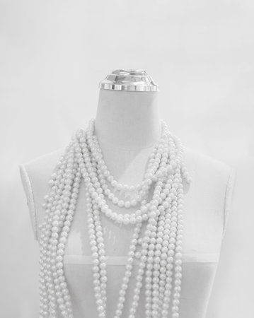 Pearl necklace on a mannequin in black and white.