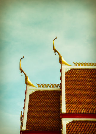 Roof Buddhist temple on sky background in Thailand, Retro style.の写真素材