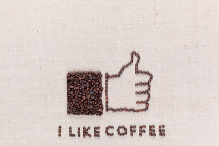 I like coffee letters and a thumbs up icon, made from roasted coffee beans on creamy linen canvas, aligned bottom center.の写真素材