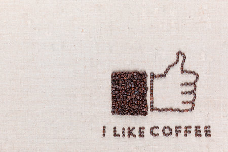 I like coffee letters and a thumbs up icon, made from roasted coffee beans on creamy linen canvas, aligned bottom right.の写真素材