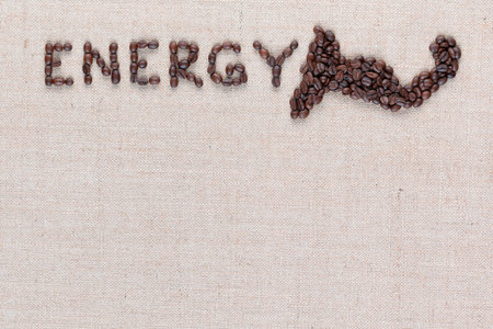 Energy word with a muscle icon made from roasted coffee beans on creamy linen canvas, shot close up, aligned topの写真素材