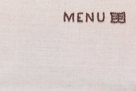 Menu word with icon made from roasted coffee beans on linen creamy linen canvas, shot from above, aligned top right.の写真素材