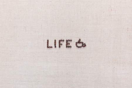 Life word with a coffee mug made from roasted coffee beans on creamy linen canvas, shot from above, aligned in center.の写真素材