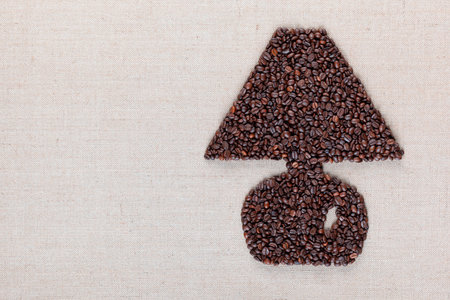 Big lamp symbol made from coffee beans on creamy linen canvas, shot top view, aligned right.の写真素材