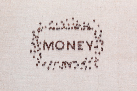 Money word surrounded by roasted coffee beans on creamy linen canvas, shot from above, aligned centered.の写真素材