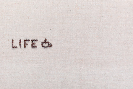 Life word with a coffee mug made from roasted coffee beans on creamy linen canvas, shot from above, aligned middle left.の写真素材