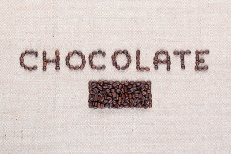 Chocolate word written with coffee beans on creamy linea canvas, shot from above, aligned in center ,close up.の写真素材