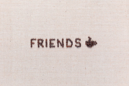 The word friends next to a hot coffee mug all made up from coffee beans ,aligned in the center.の写真素材