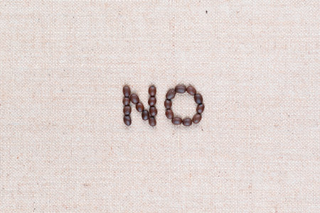 The word No written with coffee beans on creamy linea canvas, shot from above, aligned in the center,close up.の写真素材