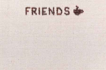 The word friends next to a hot coffee mug all made up from coffee beans ,aligned at the top.の写真素材