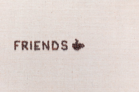 The word friends next to a hot coffee mug all made up from coffee beans ,aligned to the left.の写真素材