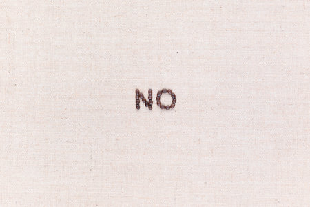 The word No written with coffee beans on creamy linea canvas, shot from above, aligned in the center.の写真素材