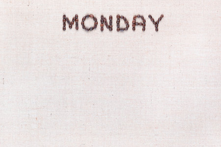 The word Monday written with coffee beans on creamy linea canvas, shot from above , aligned at the top.の写真素材