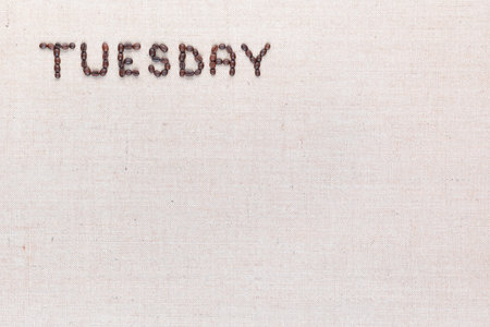 The word Tuesday written with coffee beans on creamy linea canvas, shot from above , aligned at the top left.の写真素材