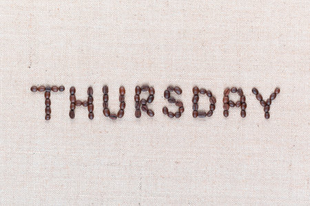 The word Thursday written with coffee beans on creamy linea canvas, shot from above , aligned in the center, closeup.の写真素材