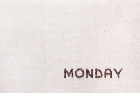 The word Monday written with coffee beans on creamy linea canvas, shot from above , aligned at the bottom right.の写真素材
