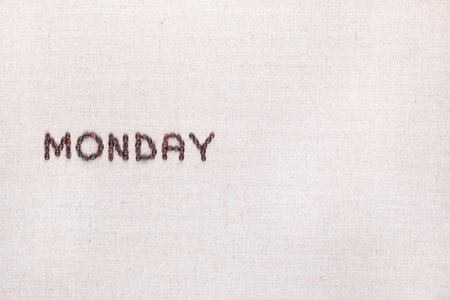 The word Monday written with coffee beans on creamy linea canvas, shot from above , aligned to the left.の写真素材