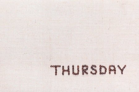 The word Thursday written with coffee beans on creamy linea canvas, shot from above , aligned at the bottom right.の写真素材
