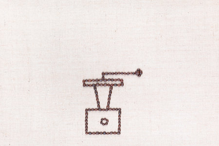 A coffee grinder made from coffee beans on creamy linea canvas, shot from above , aligned at the bottom.の写真素材