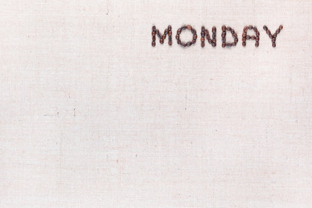 The word Monday written with coffee beans on creamy linea canvas, shot from above , aligned at the top right.の写真素材