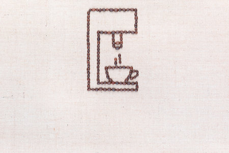 A coffee machine preparing a hot cup of coffee all made from coffee beans on creamy linea canvas, shot from above, aligned at the top.の写真素材