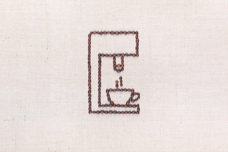 A coffee machine preparing a hot cup of coffee all made from coffee beans on creamy linea canvas, shot from above, aligned in the center.の写真素材