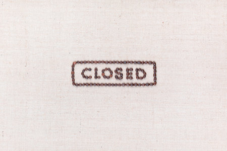 The word Closed inside a rectangle written with coffee beans on creamy linea canvas, shot from above, aligned in the center.の写真素材