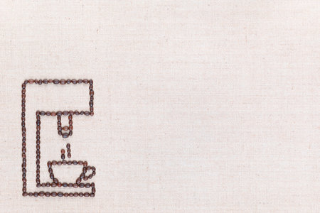 A coffee machine preparing a hot cup of coffee all made from coffee beans on creamy linea canvas, shot from above, aligned at the bottom left.の写真素材