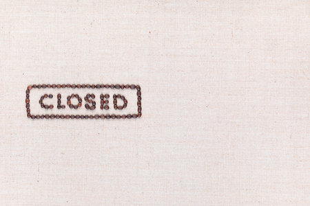 The word Closed inside a rectangle written with coffee beans on creamy linea canvas, shot from above, aligned to the left.の写真素材