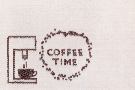 A coffee machine preparing a hot coffee next to the words Coffee Time which are inside a circle all made with coffee beans shot from above, aligned at the bottom left.の写真素材