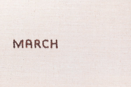 The word March written with coffee beans on creamy linea canvas, shot from above, aligned to the left.の写真素材