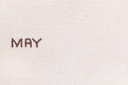 The word May written with coffee beans on creamy linea canvas, shot from above, aligned to the left.の写真素材