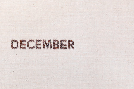 The word December written with coffee beans on creamy linea canvas, shot from above, aligned to the left.の写真素材