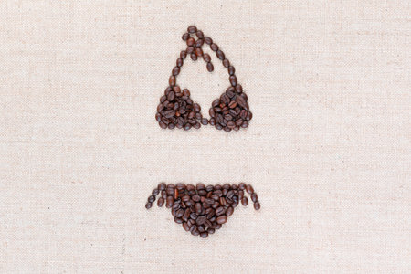 A bikini with with coffee beans on creamy linea canvas, shot from above, aligned in the center.の写真素材