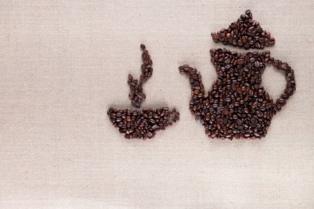 Roasted coffee beans forming steamy cup and pot on linen surface, aligned top rightの写真素材