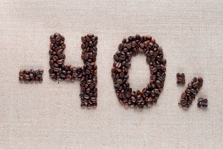 Roasted coffee beans shaping 40% off writing on creamy linen background, aligned in center, shot close upの写真素材