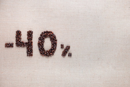 Roasted coffee beans shaping 40% off writing on creamy linen background, aligned middle leftの写真素材