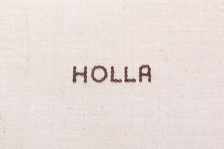 The word Holla written with coffee beans on creamy linea canvas, shot from above, aligned in the center.の写真素材