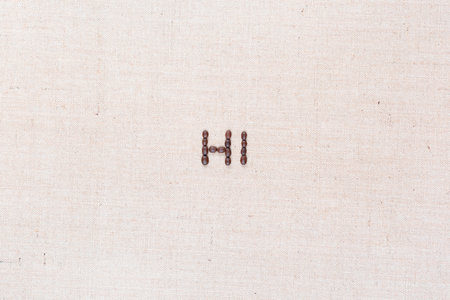 The word Hi written with coffee beans on creamy linea canvas, shot from above, aligned in the center.の写真素材