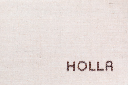 The word Holla written with coffee beans on creamy linea canvas, shot from above, aligned at the bottom right.の写真素材
