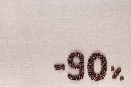Roasted coffee beans shaping 90% off writing on creamy linen background, aligned bottom rightの写真素材