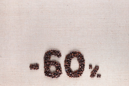Roasted coffee beans shaping 60% off writing on creamy linen background, aligned bottom centerの写真素材