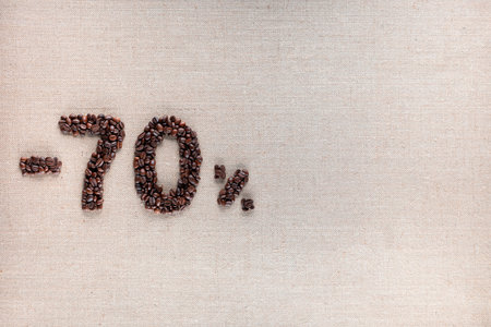 Roasted coffee beans shaping 70% off writing on creamy linen background, aligned middle leftの写真素材