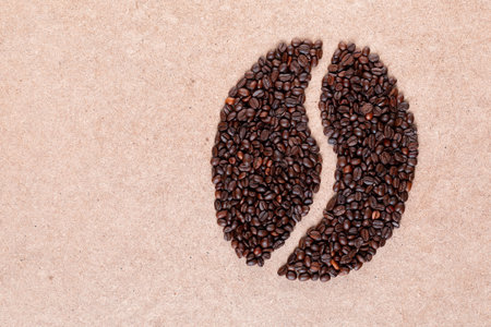 Bunch of roasted beans forming bean shape on plywood surfaceの写真素材