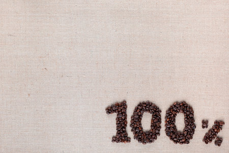 Roasted coffee beans shaping 100% off writing on creamy linen background, aligned bottom rightの写真素材