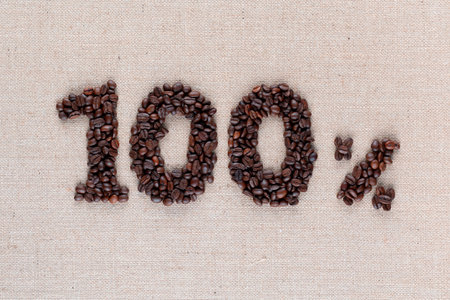 Roasted coffee beans shaping 100% off writing on creamy linen background, shot close upの写真素材