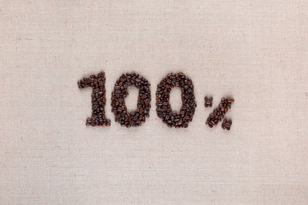 Roasted coffee beans shaping 100% off writing on creamy linen background, aligned in centerの写真素材