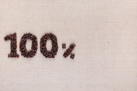 Roasted coffee beans shaping 100% off writing on creamy linen background, aligned middle leftの写真素材